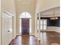 Bright foyer with tall ceilings, wood floors, columns, and an arched front door with side lights at 12340 Preserve Ln, Alpharetta, GA 30005