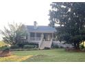 Quaint home featuring a covered front porch, complemented by lush greenery and a spacious yard at 1424 Belmont Rd, Villa Rica, GA 30180