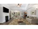 Bright living room with a fireplace, ceiling fan, and an open dining area at 210 Arbor Creek Dr, Dallas, GA 30157