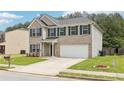 Lovely 2 story house with a 2 car garage, green lawn, and nice landscaping at 6904 Estepona St, Atlanta, GA 30349