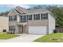 Charming two-story home with attached two car garage and neat lawn at 6904 Estepona St, Atlanta, GA 30349