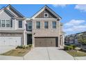 Attractive townhome with two-car garage, brick accents, and well-maintained landscaping at 7676 Viking Rd, Fairburn, GA 30213