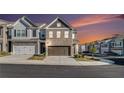 Beautiful townhome with a two-car garage and charming brick and siding exterior during sunset at 7676 Viking Rd, Fairburn, GA 30213