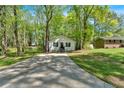 A home exterior is showcased with a lengthy driveway, green trees, and well manicured lawn at 113 Fowler Dr, Bowdon, GA 30108