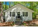 Charming exterior with an American flag, flower pots, a black door, and black shutters at 113 Fowler Dr, Bowdon, GA 30108