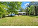 Nice lawn with trees surrounding the home with black shutters at 135 Longview Rd, Fayetteville, GA 30214