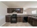 Well-lit kitchen featuring brown cabinets, black appliances, and durable countertops at 1401 Kala Dr, Lithonia, GA 30058