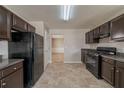 Traditional kitchen with brown cabinets, granite countertops, and black appliances at 1401 Kala Dr, Lithonia, GA 30058