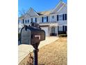 View of townhouse featuring a mailbox in front of a home with a two-car garage at 3723 Verde Glen Ln, Cumming, GA 30040