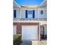 Townhouse with brick accents, a single-car garage, and a welcoming front door at 3723 Verde Glen Ln, Cumming, GA 30040