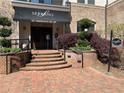 Welcoming entrance to Serrano building with brick walkway and lush greenery at 901 Abernathy Ne Rd # 5050, Atlanta, GA 30328