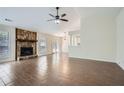 Open living room featuring a stone fireplace, fan and wood-look tile flooring at 2939 Owens Point Nw Trl, Kennesaw, GA 30152