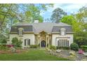 Stately home with manicured lawn, lush landscaping, and charming architectural details at 315 Mossy Pointe, Duluth, GA 30097