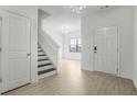 Inviting foyer with bright white walls, hardwood floors, and a staircase at 4740 Alford Commons, Cumming, GA 30028