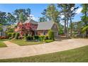 A brick and gray two-story home with mature landscaping and a circular driveway at 744 Edgewater Nw Ln, Kennesaw, GA 30144