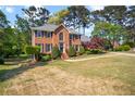 Charming two-story brick home with manicured lawn and mature trees at 744 Edgewater Nw Ln, Kennesaw, GA 30144