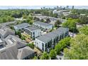 A stunning aerial view showcases modern townhomes nestled among lush trees with a city skyline in the distance at 1268 Appleden Way # 17, Brookhaven, GA 30319