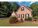Well-maintained brick home with lush landscaping, green lawn, and black shutters on windows at 219 Garden W Walk, Hampton, GA 30228