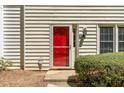Up-close view of a bright red front door with modern fixtures and manicured landscaping in a townhome community at 223 Chads Ford Way, Roswell, GA 30076