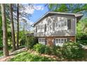 Up close exterior view of the home's two story siding and brick facade, showing window shutters and lush foliage at 4044 Ashentree Dr, Brookhaven, GA 30341
