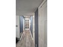 Hallway with light gray walls and wood-look vinyl flooring leading to a door at 6433 Stone Way, Morrow, GA 30260