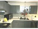 This home's kitchen is equipped with stainless steel appliances and grey cabinets at 6433 Stone Way, Morrow, GA 30260