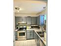 Kitchen featuring stainless steel appliances, grey cabinetry, and mosaic backsplash at 6433 Stone Way, Morrow, GA 30260
