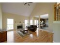 Spacious living room with hardwood floors, fireplace, vaulted ceilings, and view to kitchen at 2340 Bexford Vw, Cumming, GA 30041