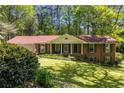 Attractive brick home with a well-kept lawn, featuring an attached garage and charming front porch at 2927 Ponderosa Cir, Decatur, GA 30033
