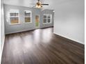 Spacious living room with hardwood floors, neutral paint, abundant natural light, and a ceiling fan at 148 Hill Side Way, Hiram, GA 30141