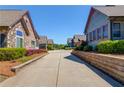 View from driveway showing manicured landscaping surrounding attractive brick and siding homes at 4321 Lanier Ridge Walk # 1704, Cumming, GA 30041