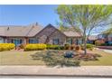 Beautiful brick home with manicured lawn, colorful shrubs, mature tree, and sidewalk at 4321 Lanier Ridge Walk # 1704, Cumming, GA 30041