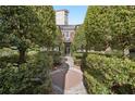 Exterior shot of a condo unit framed by manicured trees and shrubs, featuring a brick pathway leading to the front entrance at 55 Delmont Ne Dr # D1, Atlanta, GA 30305