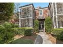Exterior view of condo unit with a screened porch, brick facade, manicured shrubs, and a walkway leading to the entrance at 55 Delmont Ne Dr # D1, Atlanta, GA 30305