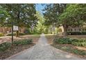 Exterior shot of condo complex showcasing landscaping, a walkway, and mature trees surrounding the property at 55 Delmont Ne Dr # D1, Atlanta, GA 30305