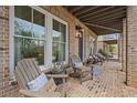 Relaxing brick-paved front porch with comfortable seating, lantern lighting and outdoor decor at 1004 Baldwin Dr, Milton, GA 30009