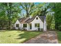 Charming white brick home featuring a well-manicured lawn and a curved roofline at 1027 Mount Airy Sw Dr, Atlanta, GA 30311