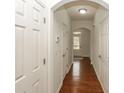 Hallway featuring hardwood floors, white trim, and access to various rooms with white doors at 5260 Sherwood Way, Cumming, GA 30040