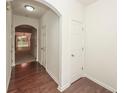 Hallway with hardwood floors leads to a living area visible through an arched doorway at 5260 Sherwood Way, Cumming, GA 30040