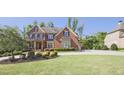 Beautiful brick home featuring a lush green lawn, mature trees, and an inviting driveway at 2331 Kinsale Nw Pt, Kennesaw, GA 30152