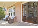 Inviting front porch with stone flooring, wicker chairs, and view to the home's entryway at 2331 Kinsale Nw Pt, Kennesaw, GA 30152