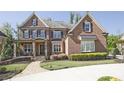 Charming two-story brick home with manicured lawn and colorful landscaping at 2331 Kinsale Nw Pt, Kennesaw, GA 30152