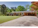 Traditional brick home with an attached carport, long driveway, and a beautifully landscaped front yard at 3397 Old Jonesboro Rd, Hapeville, GA 30354