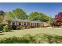 Quaint brick home featuring manicured lawn, colorful shrubs, and a classic, inviting facade at 3397 Old Jonesboro Rd, Hapeville, GA 30354