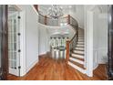 Bright foyer with hardwood floors, curved staircase, chandelier, and views into the living room at 5422 Heyward Square Pl, Marietta, GA 30068