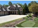 Stunning brick home with a three-car garage, putting green, and meticulously landscaped front yard at 187 Slate Dr, Buford, GA 30518