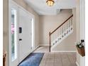 Inviting foyer features tile flooring, a staircase with white railings, and a bright front door at 4095 Fastnet Ln, Duluth, GA 30096