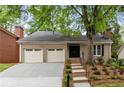 Attractive brick home with a two-car garage, front yard landscaping, and a paved driveway at 1205 Club Walk Ne Dr, Brookhaven, GA 30319