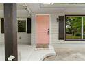 Close-up of the cheerful pink front door framed by dark shutters and a well-maintained porch at 1217 Topaz Ln, Villa Rica, GA 30180