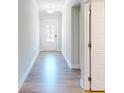 Bright hallway with gleaming hardwood floors leading to a glass-paned door at 1673 Dover Creek Ln, Lawrenceville, GA 30045